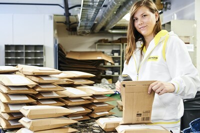 Asendia employee at a packing facility, using the advanced technology to efficiently track and manage customers' orders to maintain our service levels and build customer loyalty.