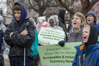 Blind, low vision, and sighted protestors of all ages shout passionately in the rain during Show Me the Money: Marching Together for Accessible and Inclusive Currency on Friday, March 10, 2023 in Washington, DC. The US Treasury is currently redesigning the $20 bill to include a portrait of Harriet Tubman, and a 2008 Federal Court Order says that any new currency redesigns must include accommodations to individuals who are blind or low vision. On Harriet Tubman Day, supporters came together for a rally in front of the White House with one clear demand: we need accessible and inclusive currency now!