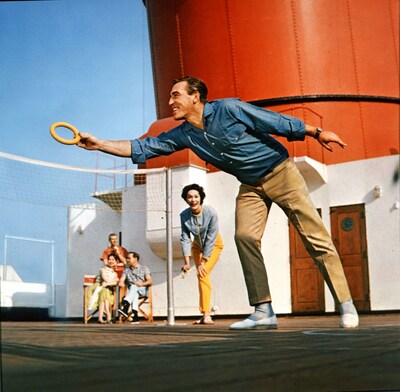 A Cunard passenger catches a hoop during a deck game in this undated shot, with the ship's funnel pictured in the background.