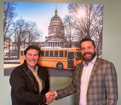 Brendan Riley welcomes John McDavid to the South Charleston facility in front of a BEAST photo in the lobby.