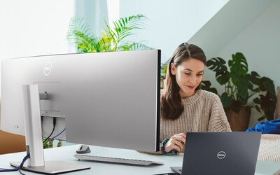 Woman working using a Dell UltraSharp 49 Curved USB-C Hub Monitor.