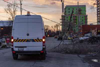 A parked hydro van near a downed wire and a tree branch covered in ice (CNW Group/Hydro Ottawa Holding Inc.)