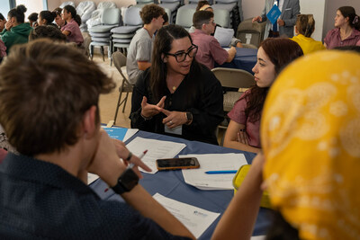 PenFed Bilingual Service Team Lead Keish Denaro Alicea speaks with University Gardens High School students during a speed networking activity.