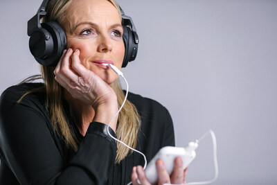 Woman using Lenire Tinnitus Treatment device