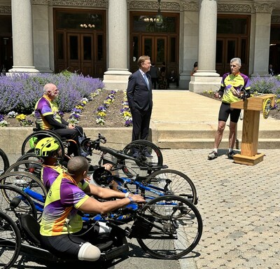 The Cigna Group Chairman and CEO David Cordani speaks outside the Connecticut State Capitol building on Thursday, May 18. He is with Governor Ned Lamont and members of the Achilles International Freedom Team. The athletes are taking part in a 500-mile relay from Boston to Washington, D.C. and Cordani guided the Freedom Team, a group within Achilles International comprised of wounded military personnel and veterans, on a bicycle from The Cigna Group's headquarters through downtown Hartford.