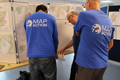 MapAction volunteers review details on a map on the 'map wall'. Photo: MapAction