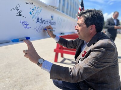 David Ottati, president and CEO of the AdventHealth West Florida Division, adds his name and a message of pride to the last beam to be installed into AdventHealth Riverview.