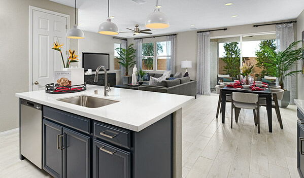Kitchen island with three light fixtures above and living room and dining table behind it