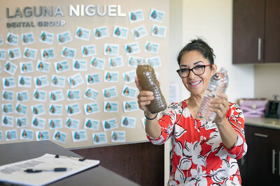A team member at Laguna Niguel Dental Group in Laguna Niguel, Calif. holds up two bottles of water?one clear, the other dirty?to showcase the stark contrast between clean and contaminated water and shed light on the challenging conditions faced by those in Ethiopia without access to safe drinking water.