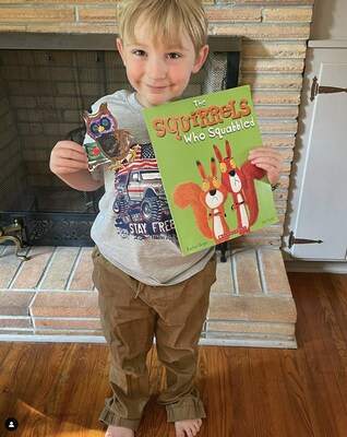 Elementary school student Nathaniel with The Squirrels who Squabbled, a book provided by the K-3 Home Library Program from the Governor’s Early Literacy Foundation in collaboration with Scholastic.