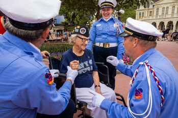 LAKE BUENA VISTA, Fla. (June 7, 2023) – World War II and U.S. Navy veteran, Dorothy “Pat” Rudd, speaks with Magic Kingdom Security cast members prior to her being honored as Veteran-of-the-Day during the daily Flag Retreat Ceremony in Magic Kingdom Park at Walt Disney World Resort.  (Photo credit: Disney)