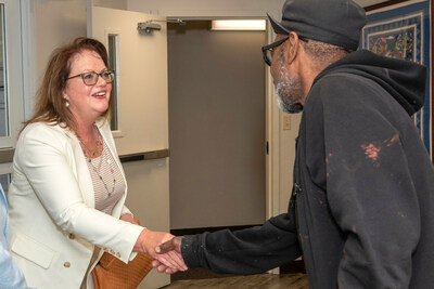 Washington Trust President & Chief Operating Officer, Mary Noons greets a McAuley Village guest.