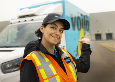 READY TO ROLL: Voilà Driver and teammate Tina Saeedi stands alongside a Voilà delivery van outside the new Customer Fulfillment Centre (CFC) in Rocky View County, AB. Voilà is now delivering nearly 20,000 products from Safeway, Sobeys, Chalo! FreshCo and more to communities across Alberta, such as Calgary, Edmonton, and surrounding areas. (CNW Group/Empire Company Limited)