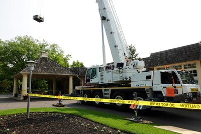 A crane carrying off an outdated rooftop HVAC unit at Cobblestone Creek Country club.