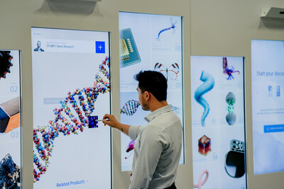 M&M Conference attendee engages with interactive digital wall featuring scientific researcher insights