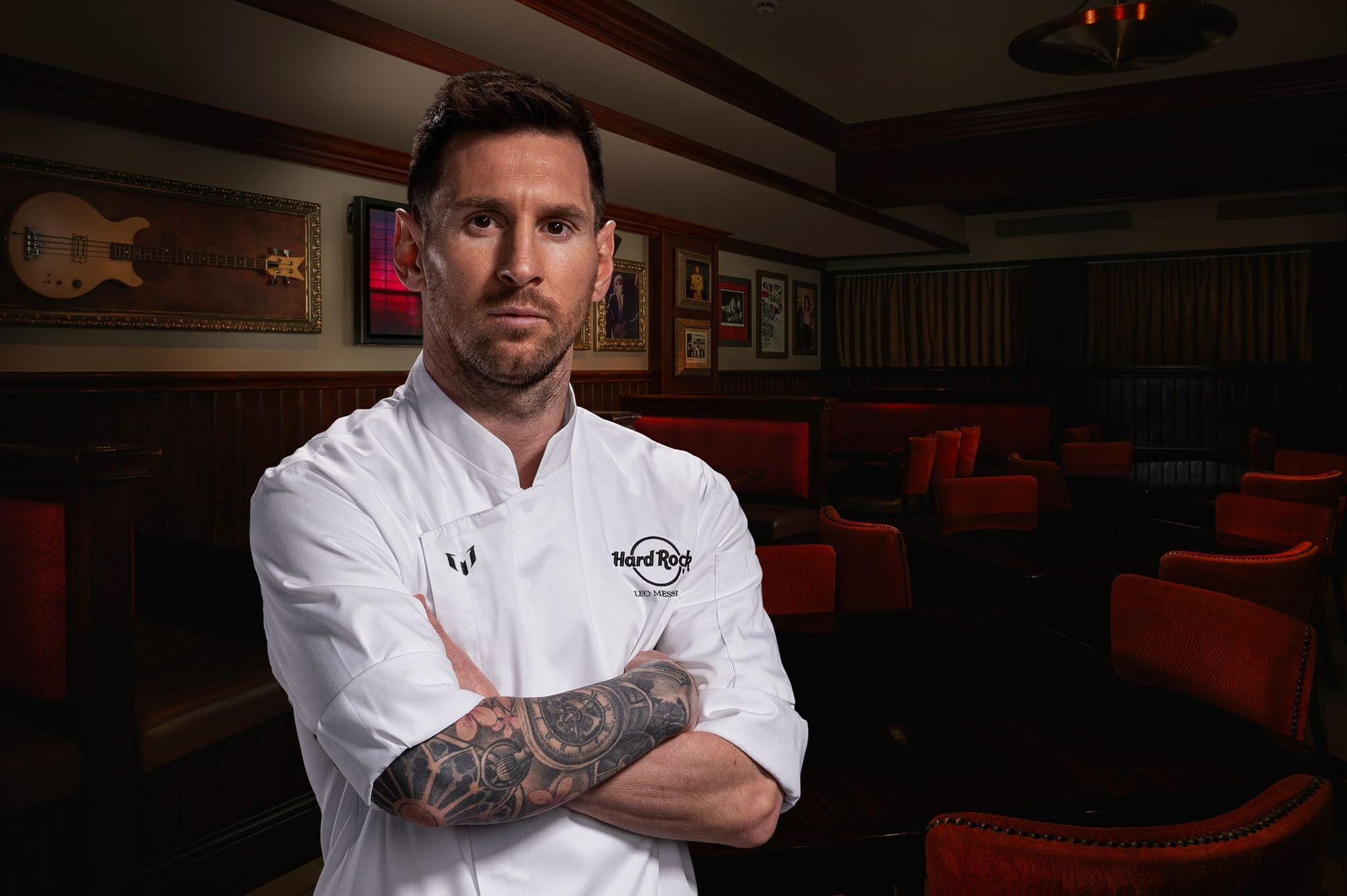 Lionel Messi posing in a Hard Rock Chef's jacket