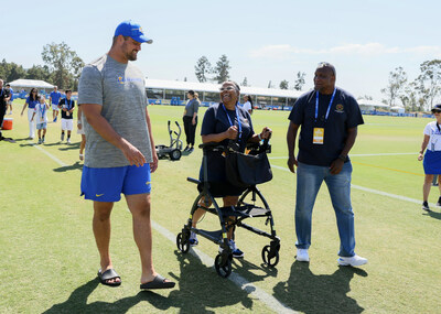 Air Force veteran Jamie Ash (center) and her husband Najee Shaheed (right) talk with Los Angeles Rams offensive lineman and 2022 Salute To Service Award nominee Rob Havenstein (left) at the LA Rams Training Camp. As part of Military Appreciation Day, Ash and an active-duty Marine supported by LA-based Fisher House received a free Princess cruise and tickets to an upcoming Rams game.