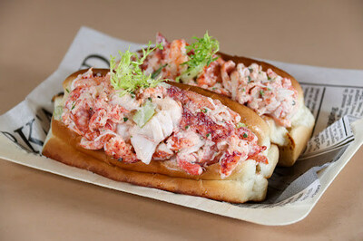 Drift Bar's Maine Style Lobster Roll featuring steamed lobster claws and knuckles, light mayo and crunchy celery greens on a toasted brioche bun