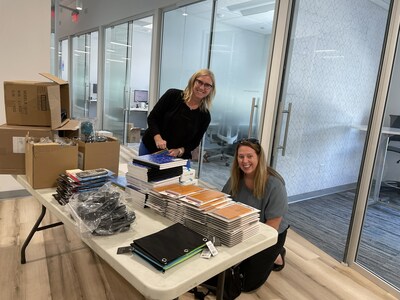 AprilAire team members (L to R) Christina Schmoker Director of Human Resources) and Sue Witthun (Senior Manager, Human Resources) fill backpacks with donated school supplies.