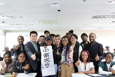 Sanele Ntuli (2.ª D), professora de mandarim do Confucius Institute na Durban University of Technology, posa para uma foto com professores e alunos com um trabalho caligráfico mostrando ?a amizade entre a China e a África do Sul? em Durban, África do Sul, em18 de agosto de 2023. /Xinhua (PRNewsfoto/CGTN)