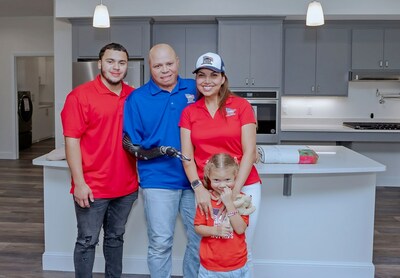 Army SSG Juan Amaris and family stand in front of the specially adapted custom home, gifted by Homes for our Troops along with corporate partners like Cinch Home Services.