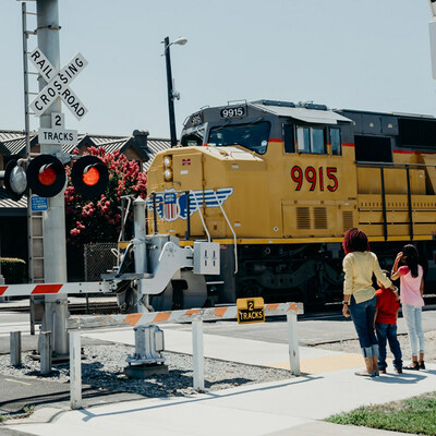 Only cross train tracks at a designated crossing. Designated crossings are marked by a sign, lights, or a gate.
