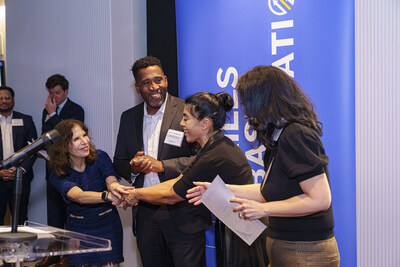 During the September 26, 2023, BuildWithin graduation event, President of the Golden Triangle BID Leona Agouridis, alongside Deputy Mayor Keith Anderson, presents a Penn West sponsorship to Ximena Hartsock Gates and Michelle Rhee, co-founders of BuildWithin.