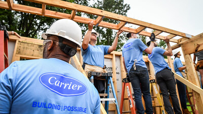Framing is lifted into place on a new Habitat home by a team of Carrier volunteers in Charlotte, North Carolina.