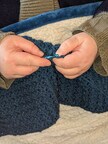 Elizabeth Drachenstrom knitting a blanket. Photo credit: Dragontree Emporium