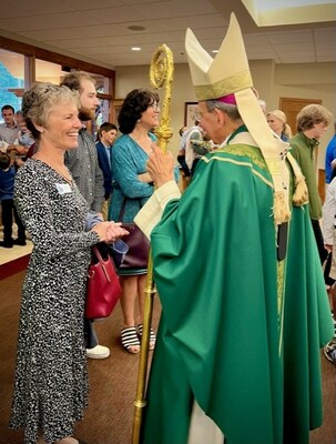 Parishioner Ruth Riley greeting Archbishop William Lori after Mass