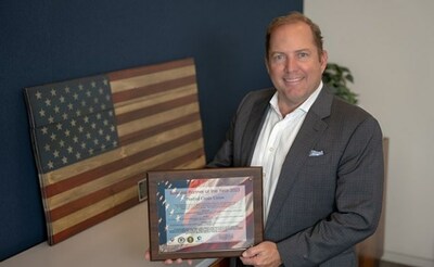 PenFed President/CEO James Schenck accepts "Business Partner of the Year" plaque from Triple Impact Communications honoring PenFed for its support of the military community.