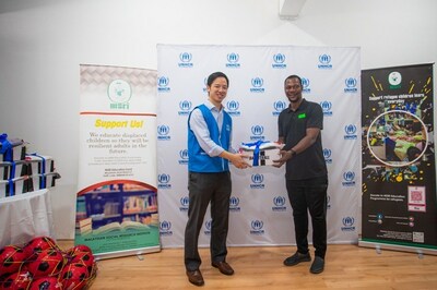 Photo credit: UNHCR/Azwan Rahim  Mr. Keane Shum, UNHCR Malaysia Senior Protection Officer, hands part of the contribution from the Moving for Change partnership to Mr. Tony Avbiorokoma, a sports coach at the MSRI learning centre for refugee children in Kuala Lumpur.