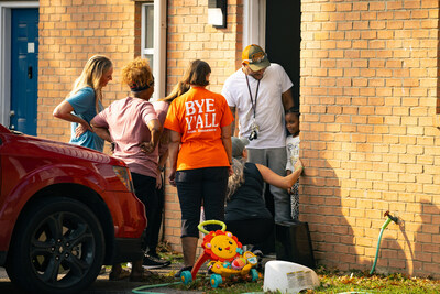 Walkers stop to pray with a family at their residence.