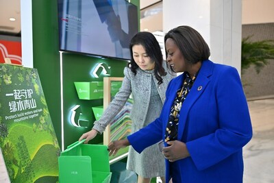 Sandy Xu (left) and Sanda Ojiambo look at JD's recyclable delivery boxes, known as the Green Stream Boxes
