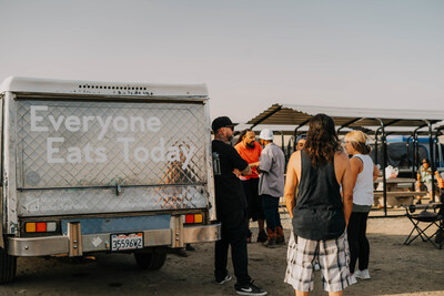 Staff and volunteers of Salt + Light handing out hot meals to people experiencing homelessness.