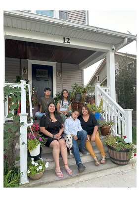Photo of the Vela family sitting in front of their home. The photo was taken by NJCC.