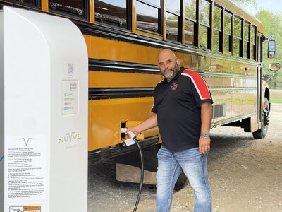 Martinsville ISD Principal Keith Kimbrough with a Blue Bird Vision electric bus, and Nuvve Level II charger