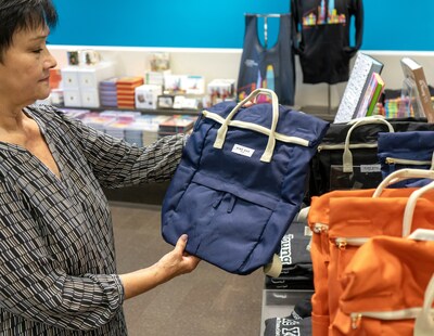 Museum shopper browsing the reusable Navy Hackney Backpack sustainably and ethically made of recycled plastic bottles by Kind Bag, available at the de Young & Legion of Honor Museum Stores in San Francisco. Photo courtesy of the de Young & Legion of Honor Museum Stores.