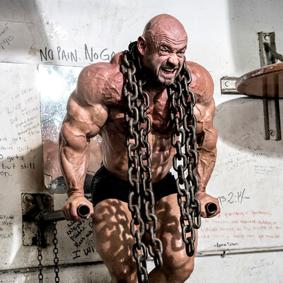 Branch Warren Bodybuilder doing dips with heavy chain around his neck