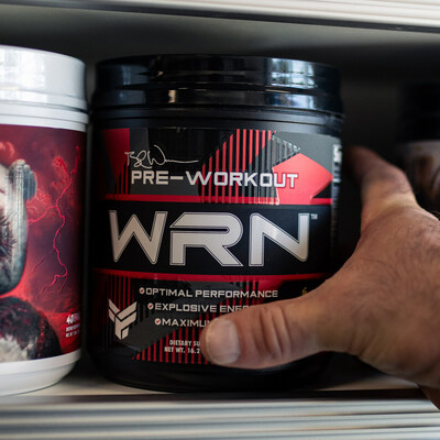 Hand grabbing WRN pre-workout off of shelf.