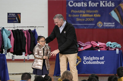During a celebration of the Coats for Kids program, Supreme Knight Patrick E. Kelly presents the 1 millionth coat to 1st grader Lexi Cordova at Annunciation Catholic School in Denver, Colorado, Nov. 6, 2023. The Knights began the program in 2009 and were marking giving away 1 million coats. (Photo by Paul Haring)