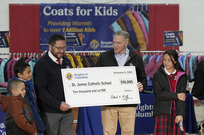 During an event celebrating the donation of the 1 millionth coat in the Coats for Kids program, Supreme Knight Patrick E. Kelly presents a $10,000 check to representatives of St. James Catholic School in Denver, Colorado, at Annunciation Catholic School in Denver Nov. 6, 2023. The Knights donated a total of $50,000 to schools in the Archdiocese of Denver during the ceremony. (Photo by Paul Haring)