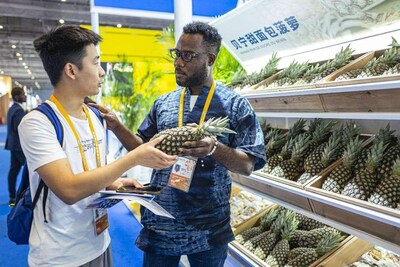 A staff member introduces pineapples from Benin at the sixth China International Import Expo, Nov. 5, 2023. (Photo by Wang Chu/People's Daily Online) (PRNewsfoto/People's Daily)