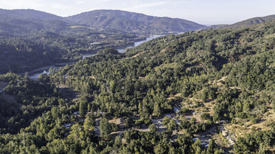 A view of Lupin Lodge's 112-acre property, in the hills above Silicon Valley, showcasing several buildings in the foreground. The perspective extends from the southwest to the northeast, with Lexington Reservoir in the background.