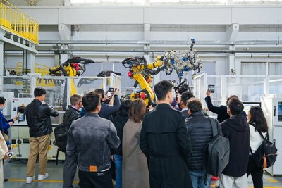 Observers watch industrial robots working based on instructions wirelessly transmitted& at high speeds via 5G-Advanced indoor base stations (PRNewsfoto/HUAWEI)