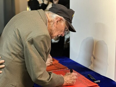 Flying Tigers veteran Mel McMullen signs his name on a guestbook at the Stilwell Museum in southwest China's Chongqing municipality. (Photo by Liu Lingling/People's Daily)
