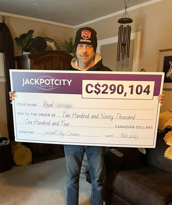 JackpotCity Ontario's recent big winner, Mr. Rheal L, receives his cheque. (CNW Group/Jackpot City)