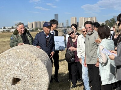 Members of a delegation of Flying Tigers veterans and their descendants listen to a docent telling the story behind a stone roller at the site of Chenggong Airport in Kunming, capital of southwest China's Yunnan province. Chenggong Airport was one of the main bases of the Flying Tigers in Kunming. During the construction of the airport, local people made tremendous efforts to level the runway with the stone roller. (Photo by Liu Lingling/People's Daily)