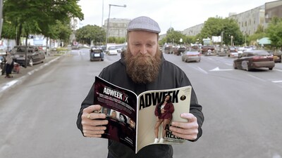 Co-CEO of Media.Monks Content Practice, Wesley ter Haar uses 12 fingers to read the latest issue of Adweek against an AI-generated background