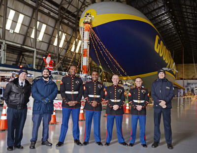 Goodyear Airships associates and U.S. Marine Corps Reserve members pose in front of the Goodyear Blimp at past Toys for Tots donation drives.